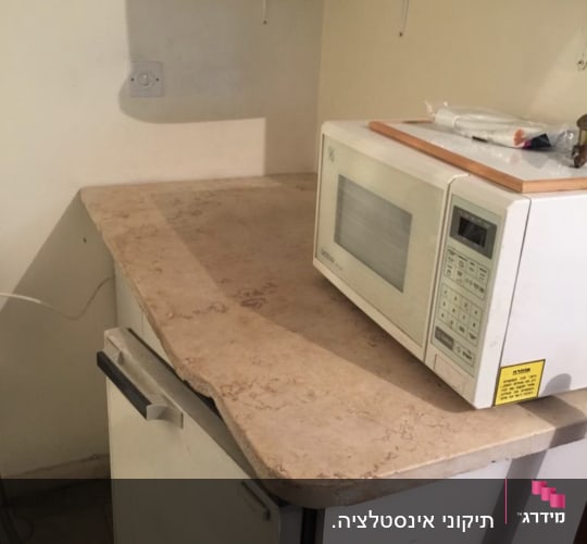 מיקרוגל על משטח עבודה במטבח